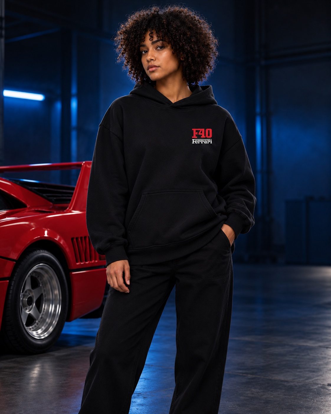 Female model wearing the black F40 hoodie in a garage with a red sports car — AI styling preview